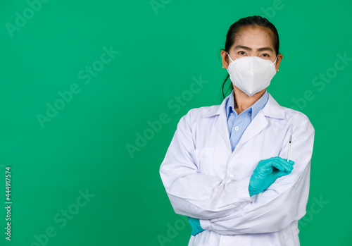 Asian female doctor wearing lab coat and mask holding syringe with Covid 19 vaccine. Concept for Covid 19 vaccination