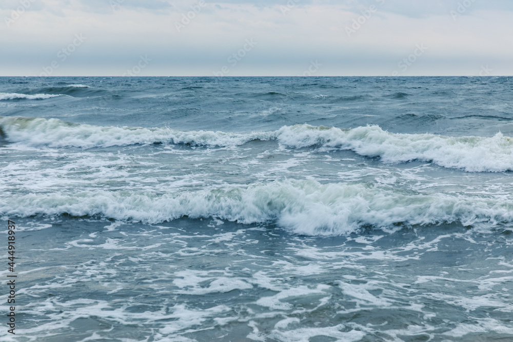 Baltic Sea coast in Poland, waves, sea foam, sky and beach