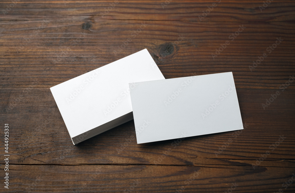 Blank business cards on wood table background. Mockup for branding identity. Blank business cards on wood table background. Mockup for branding identity.