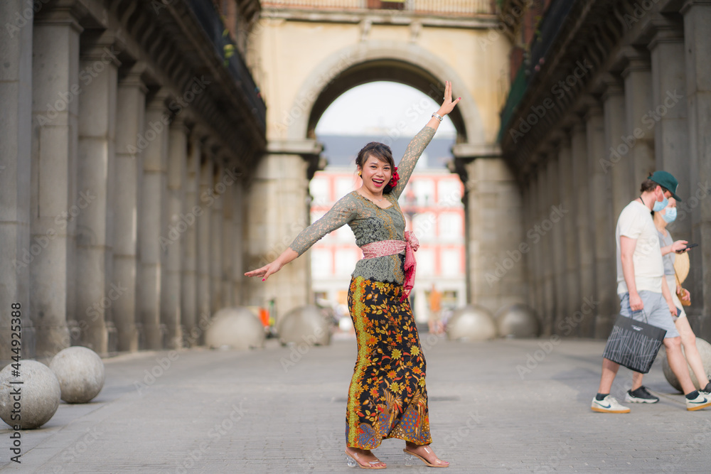 young happy and beautiful Asian woman wearing traditional Balinese kebaya dress - Indonesian girl doing Bali dance on street during holidays travel in Europe young happy and beautiful Asian woman wearing traditional Balinese kebaya dress - Indonesian girl doing Bali dance on street during holidays travel in Europe