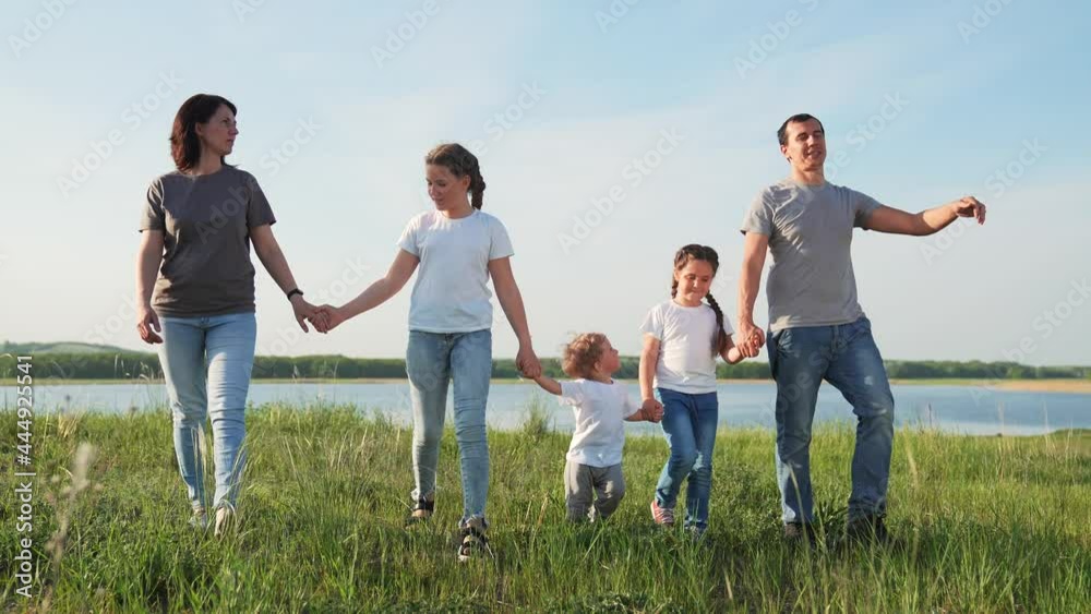 Happy family. Hiking in park. Happy cute family walking in nature park by lake. Parents with children walking. Family picnic by lake. Hiking in natural park. Children walk with their parents. Happy family. Hiking in park. Happy cute family walking in nature park by lake. Parents with children walking. Family picnic by lake. Hiking in natural park. Children walk with their parents.