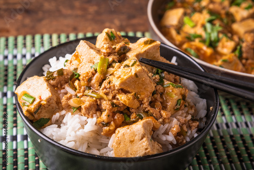 Mapo tofu in a bowl of rice close-up with chopsticks