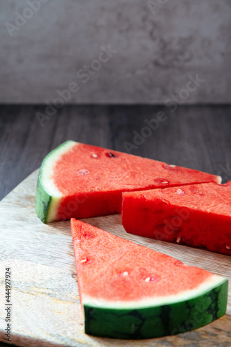 three triangular pieces of watermelon on a motherboard and rustic background