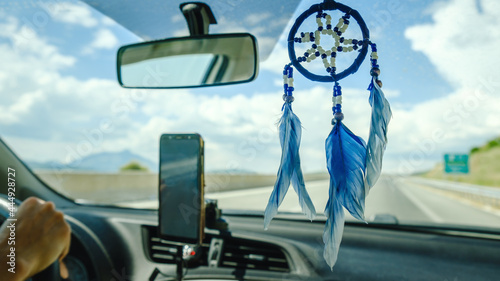 Dream catcher hanging insisde car on a backview mirror photo