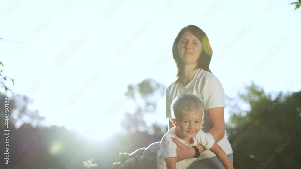 Happy family. Mom play with baby in park. Mom throws baby in her arms