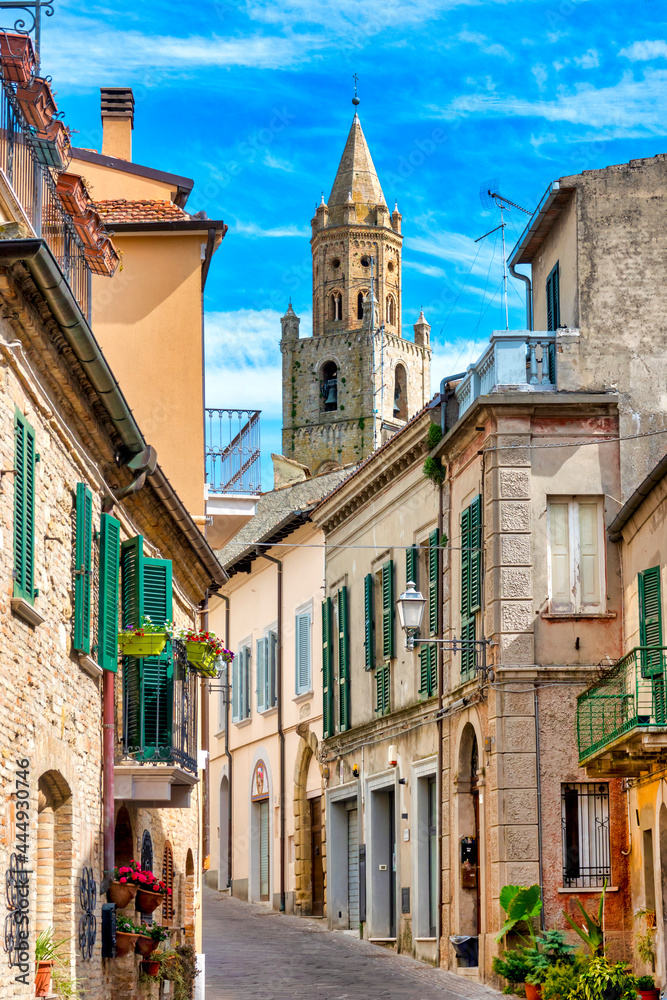 Narrow street in the town of Atri with a view of the cathedral bell tower, Italy