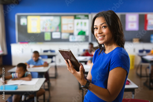 Portrait of african american female teacher holding digital tablet in the class at school