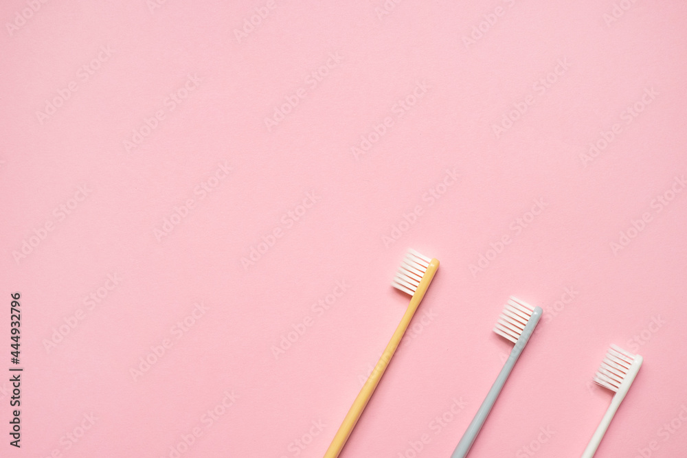 Gray and white toothbrushes on pink background.Taking care of teeth, dental concept. Flat lay photo, copy space, top view. Gray and white toothbrushes on pink background.Taking care of teeth, dental concept. Flat lay photo, copy space, top view.