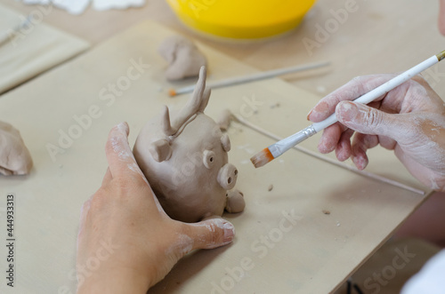 A pottery master makes a jug from clay. Hands close up