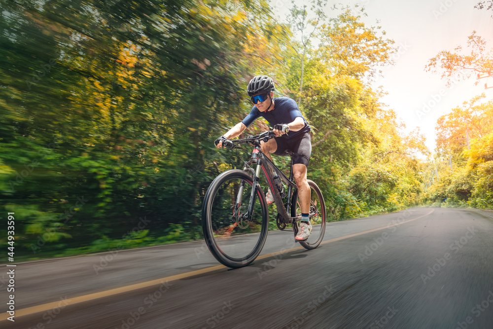 Cycling Mountain Bike Cycling MTB on the road shady with forest. Mountain biking athlete look at wild nature on mountain. Extreme Sport and MTB, mountain bike downhill of motion Concept.