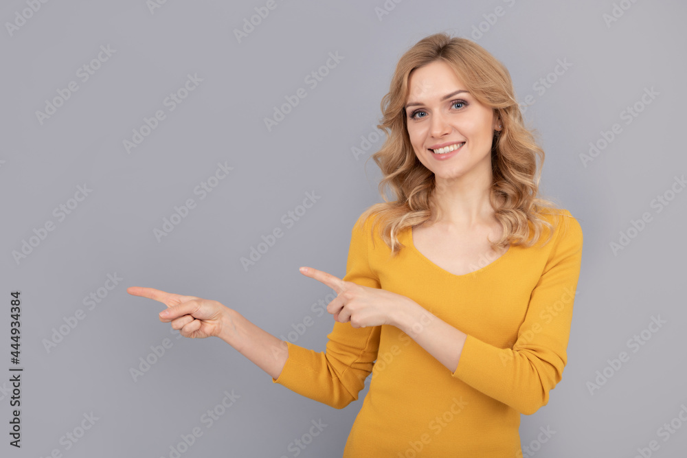 cheerful blonde beauty woman with curly hair pointing finger on copy space, advert cheerful blonde beauty woman with curly hair pointing finger on copy space, advert