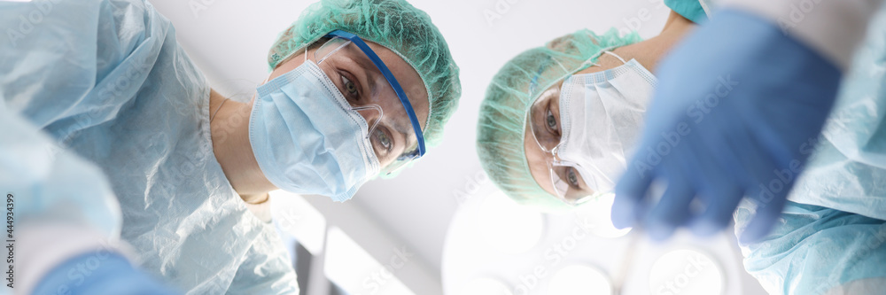 Fototapeta premium Group of doctors performing surgical operation in clinic