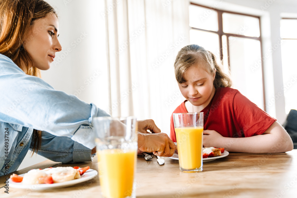 White woman and her daughter with down syndrome having breakfast