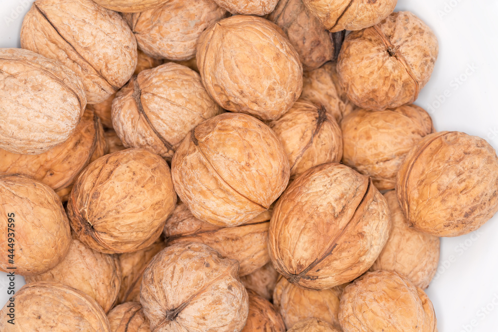 Pile of unshelled walnuts, top view close-up Pile of unshelled walnuts, top view close-up
