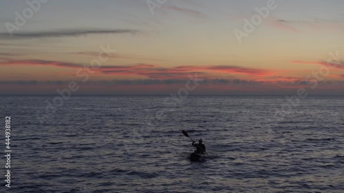 Man kayaking in the sea at sunset, aerial view