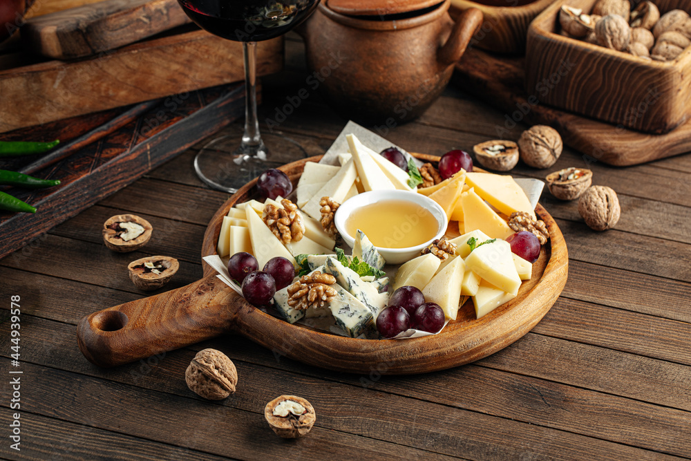 Cheese wine appetizer platter with grapes nuts and honey Cheese wine appetizer platter with grapes nuts and honey