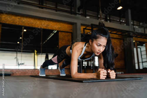 Konstfotografi Happy young Asia lady exercise doing plank fat burning workout in fitness class