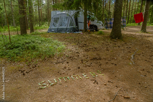 Finland Porvo. June 28, 2021 the word SUMMER is laid out on the ground with watermelon peels. In the background a caravan car with a tent photo