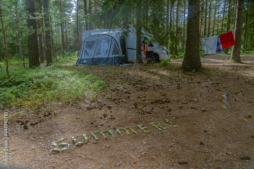 Finland Porvo. June 28, 2021 the word SUMMER is laid out on the ground with watermelon peels. In the background a caravan car with a tent photo