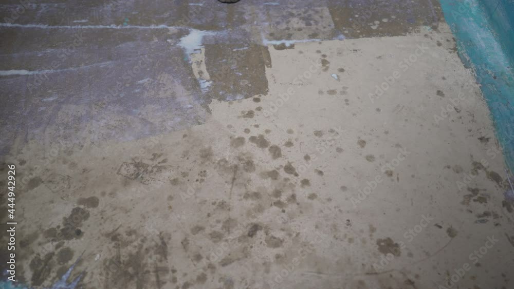 Master with a paint roller doing floor priming at home, renovation work. Floor primer. Master with a paint roller doing floor priming at home, renovation work. Floor primer.