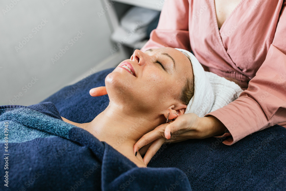 Anonymous masseuse doing massage for woman in spa salon