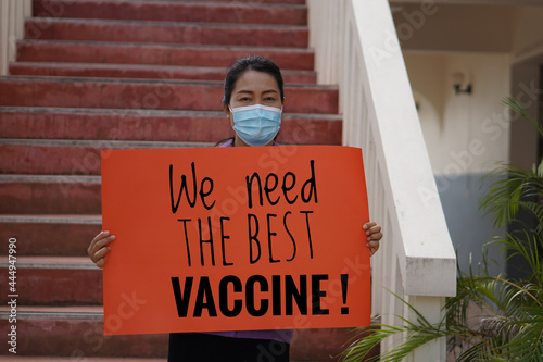 Protester holds paper sign with text " We need the best vaccine!". Concept : Asking government to support and provide the best Covid -19 vaccine for citizens.    