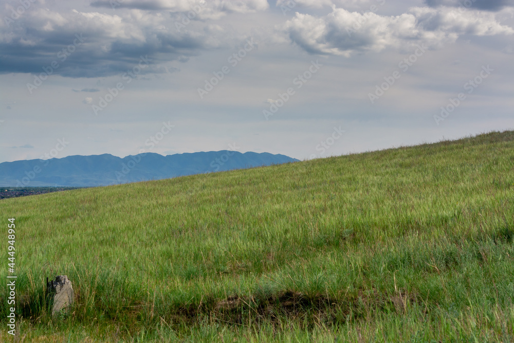 Mountain with a green hill. Cloudy weather. Summer. Zhetysu, Almaty region, Kazakhstan.