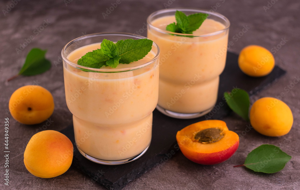 Apricot smoothie on a gray background.
Two glasses of apricot smoothie. Apricot smoothie on a gray background.
Two glasses of apricot smoothie.