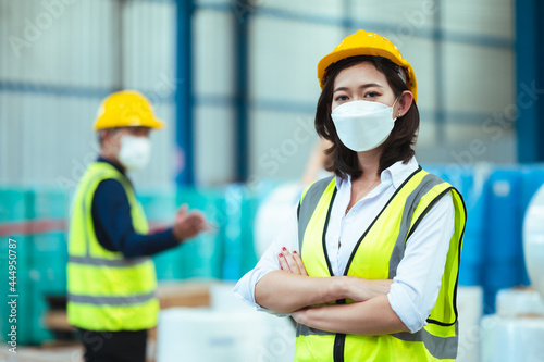 Chief industrial engineer inspects the mask factory. portrait woman while using a laptop. They show an assertive demeanor. Protective equipment in the danger zone.