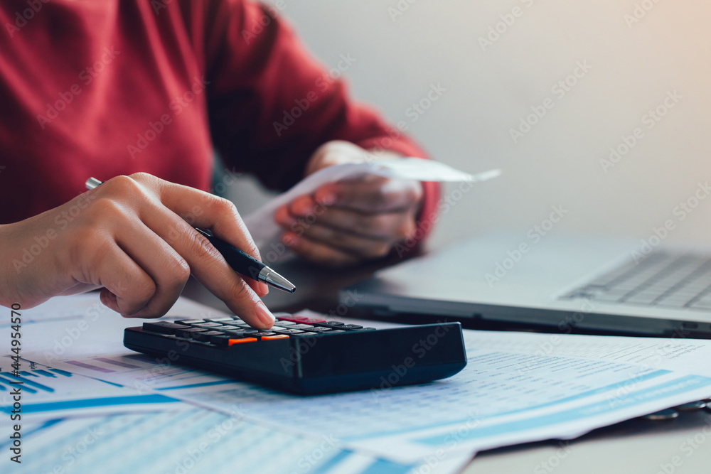 Fototapeta premium Close up woman hand using a calculator and the other hand holds the bill with calculate about finance accounting. finance accounting concept