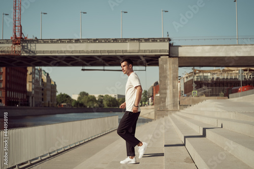 Stylish man walking downstairs in city photo