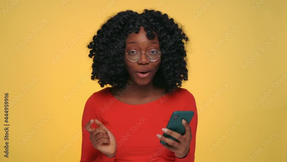 African looking at mobile screen and feeling surprised African looking at mobile screen and feeling surprised