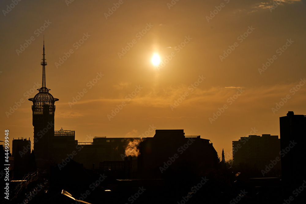 Sunset over the city. Yellow sky. Silhouettes of buildings