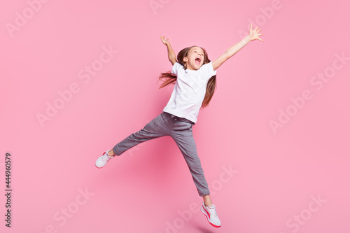 Full length body size view of pretty carefree cheerful girl jumping having fun good mood isolated over pink pastel color background