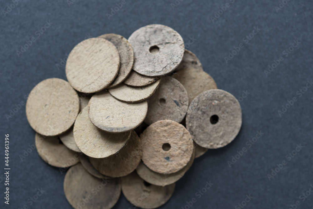 exhausted or used chipboard or cardboard end discs with soot on gray paper exhausted or used chipboard or cardboard end discs with soot on gray paper