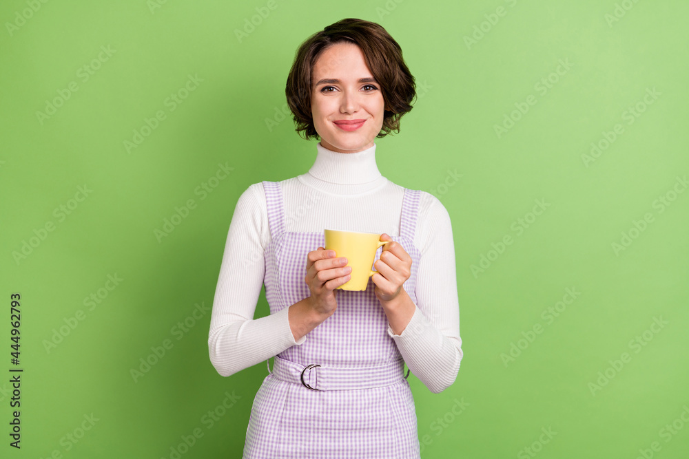 Photo portrait woman smiling drinking coffee on break isolated pastel green color background Photo portrait woman smiling drinking coffee on break isolated pastel green color background