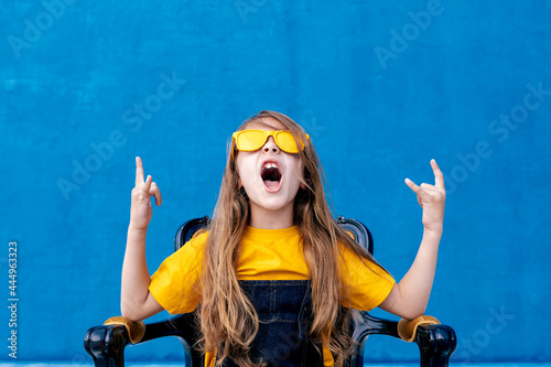 Cool teenager in sunglasses showing rock gesture photo