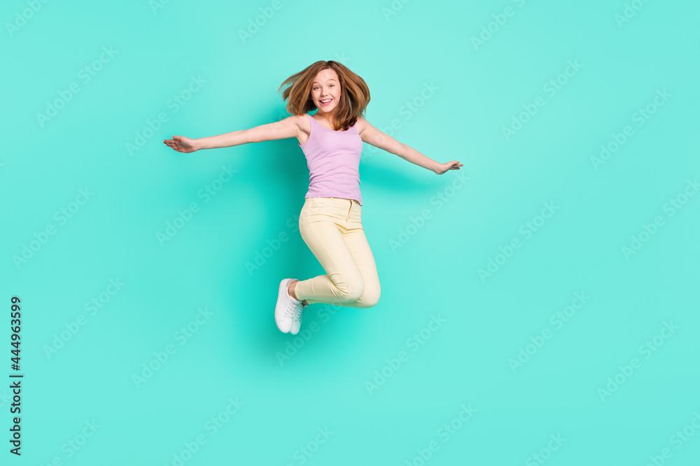 Full length photo of lovely brown teen girl jump wear top pants isolated on teal color background