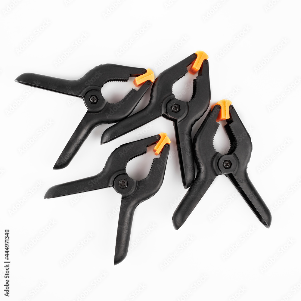 Obraz premium Spring clamp isolated on white background. Black plastic clamp. Set of small and big size. Clamping equipment for handicraft, joinery, photography, cars. 