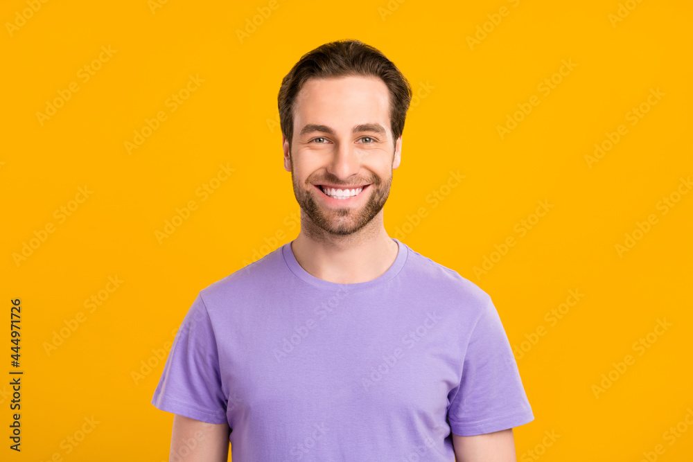 Photo of positive handsome guy look camera toothy beaming smile wear purple t-shirt isolated yellow color background Photo of positive handsome guy look camera toothy beaming smile wear purple t-shirt isolated yellow color background