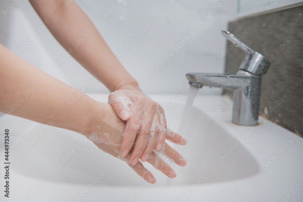 Woman use soap and washing hands under the water tap, hygiene to stop spreading coronavirus. Woman use soap and washing hands under the water tap, hygiene to stop spreading coronavirus.