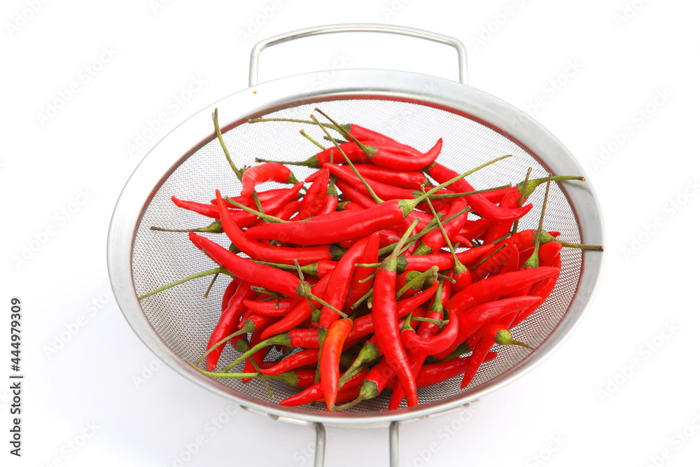 Group of fresh red hot chilli peppers in metal basket on white background Group of fresh red hot chilli peppers in metal basket on white background