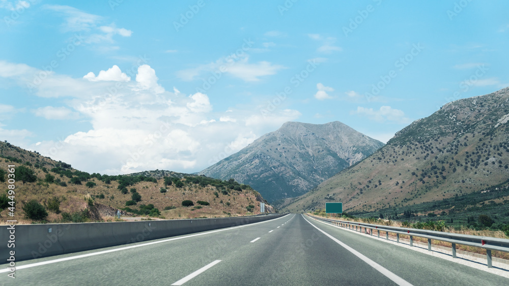 Driving car on a highway with view on scenic hills and mountains, European road.