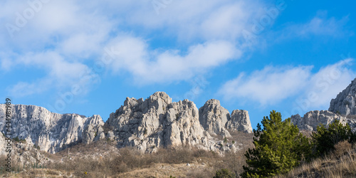 Panorama of white rocks of the main ridge of the Crimean mountains against the background of a bright blue sky