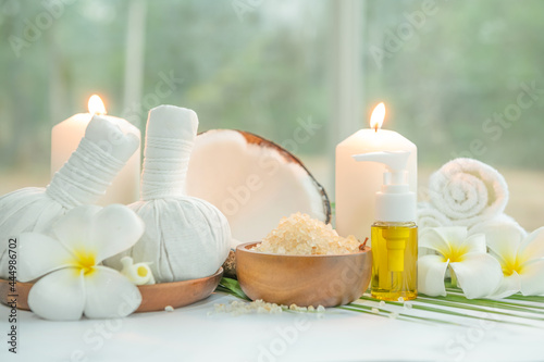 Coconut oil  tropical leaves and fresh coconuts. Spa coconut products on light wooden background. Spa still life of organic cosmetics with coconuts on a light wooden background  body care concept.
