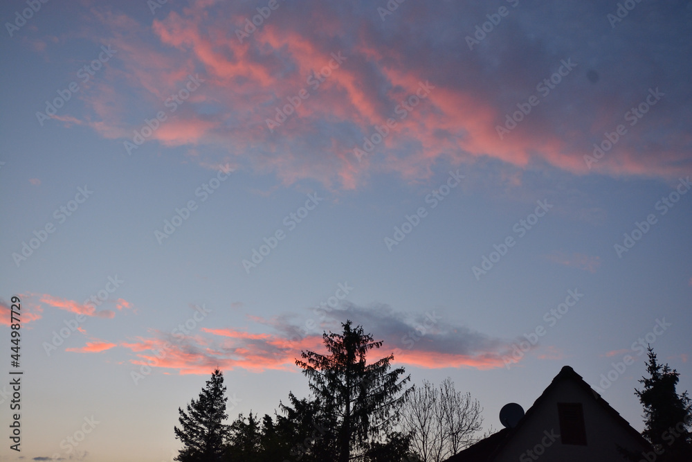 Sunset in the South of Germany with pink cloulds over a house