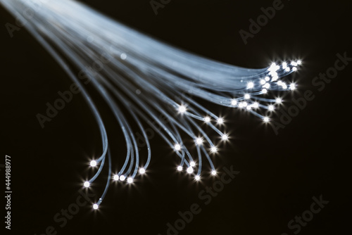 Bundle of optical fibers with lights in the ends. Black background.