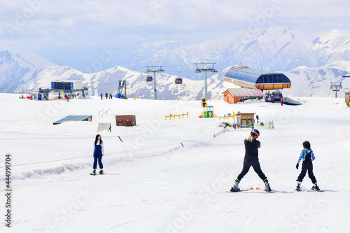 Caucasian ski instructor teaching teenager to ski in Gudauri ski resort. Ski holiday in Georgia