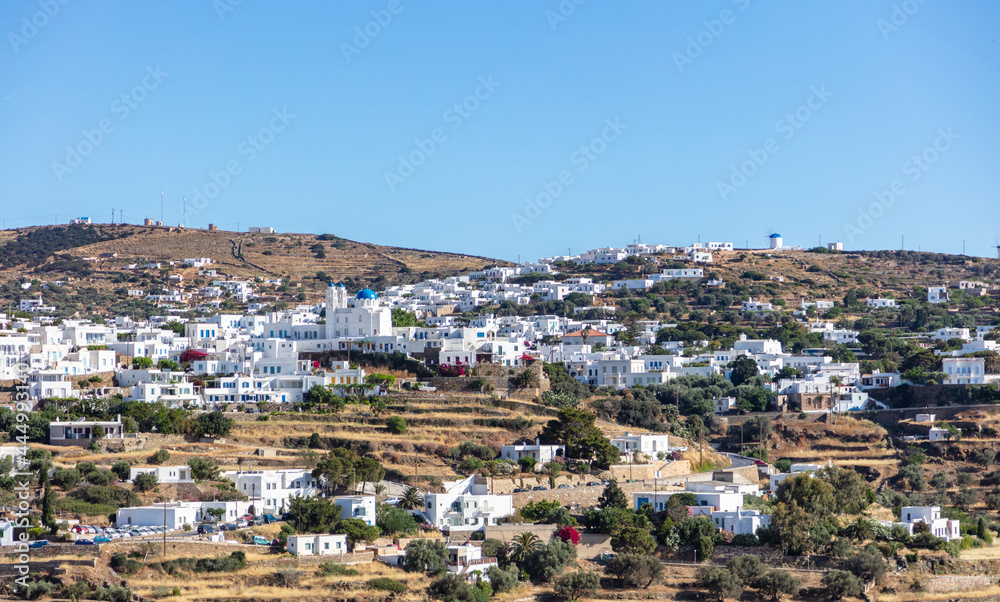 Greece. Sifnos island, Artemonas town aerial drone view. Traditional architecture, whitewashed buildings uphill, blue sky background.