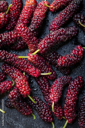 Fresh ripe Mulberries on dark background photo